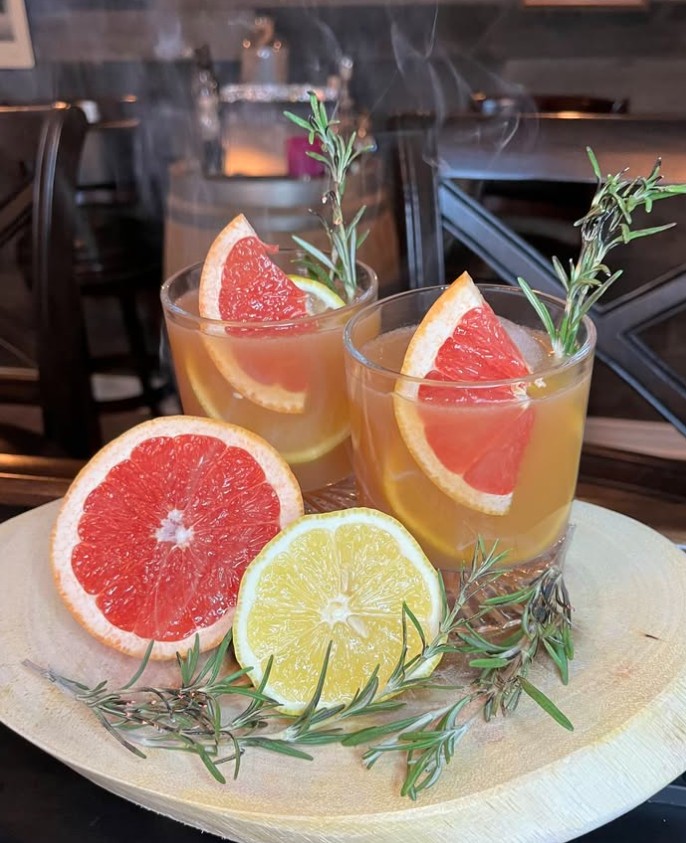 Rustic Miller’s Amish Pub Bourbon Old Fashioned with fresh lemon and smoked rosemary in a rocks glass.