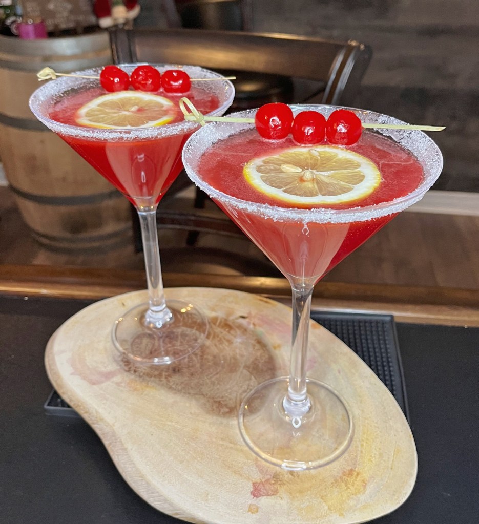 Stunning hand crafted Christmas cocktail.  Red with a white sugar rim served in a martini glass with a lemon float and 3 marischino cherries - very festive! but great for any time of year!