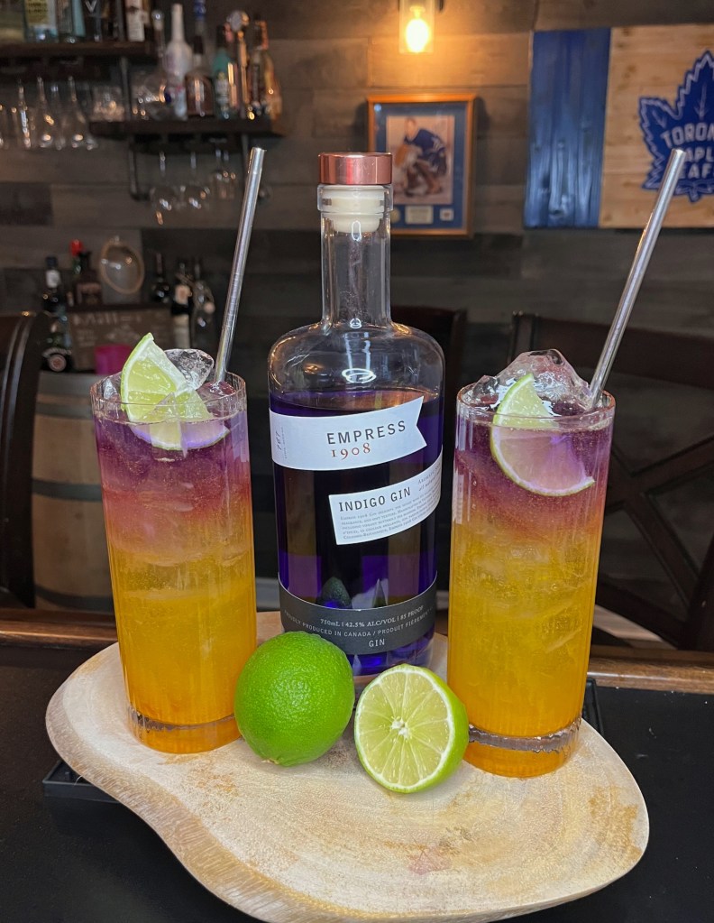 Vibrant golden Turmeric & Tonic cocktail in a Collins glass with ice, floated Empress 1908 Gin, lime wedge garnish, and a cozy winter glow – Cocktail Recipe #413 from Miller's Amish Pub

