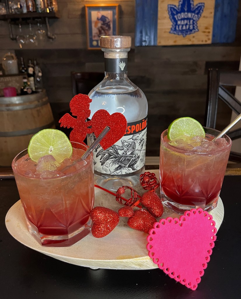 Refreshing pomegranate tequila cocktail in a 12oz tumbler filled with ice, vibrant red hue from pomegranate juice, topped with fizzy ginger ale, garnished with a fresh lime wheel