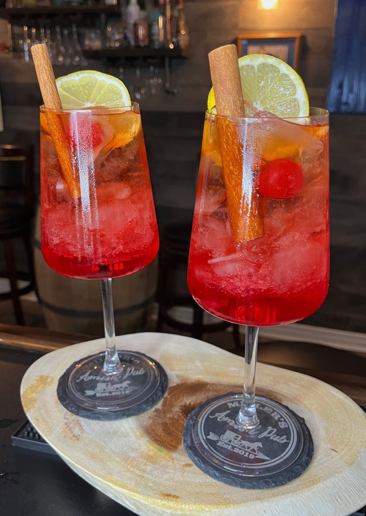 A vibrant red rum cocktail named 'The Amish Red Rum' from Miller's Amish Pub, featuring a bold red hue, rum base, and garnishes. All work and no play makes Orson a dull boy... once! Crazy tasty mixology fun. #rum #cocktail

